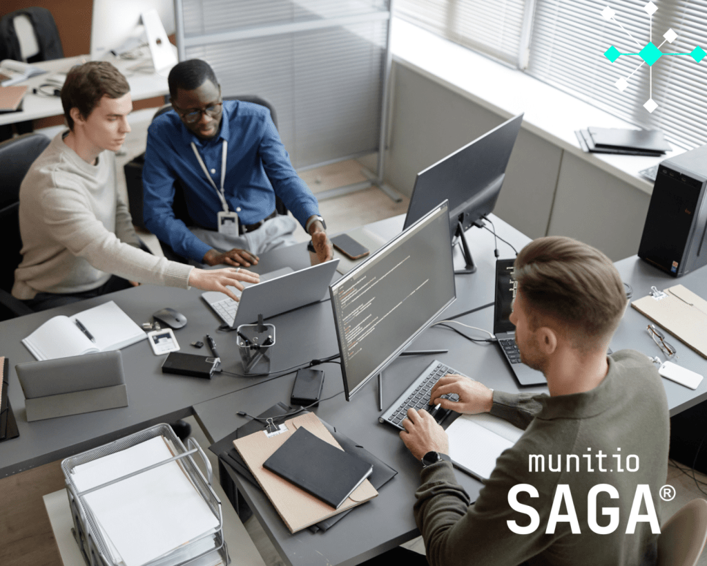 Cybersecurity team collaborates around multiple monitors displaying code and data, demonstrating real-world teamwork.