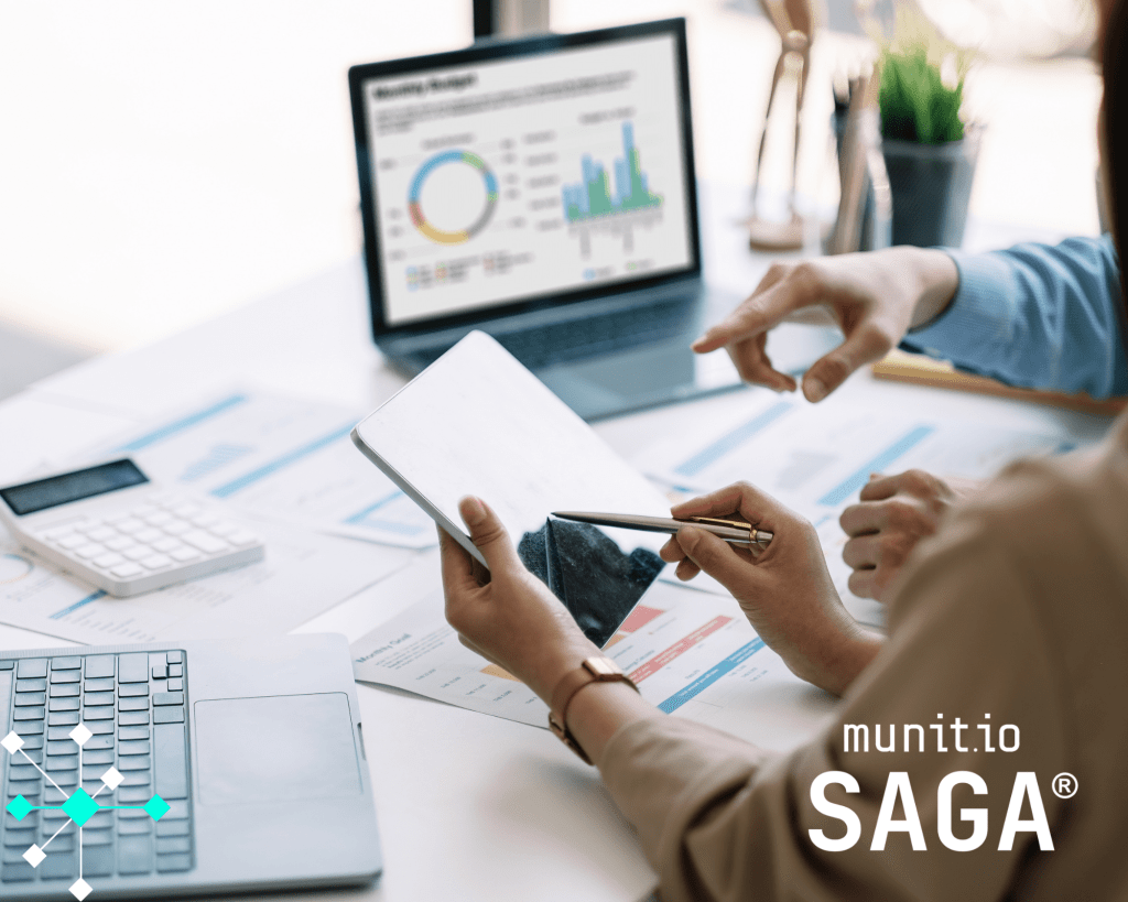 Two professionals review data analytics on a tablet and laptop, discussing visualized reports on cybersecurity performance—illustrating what do you do in cyber security when analyzing threats and trends.