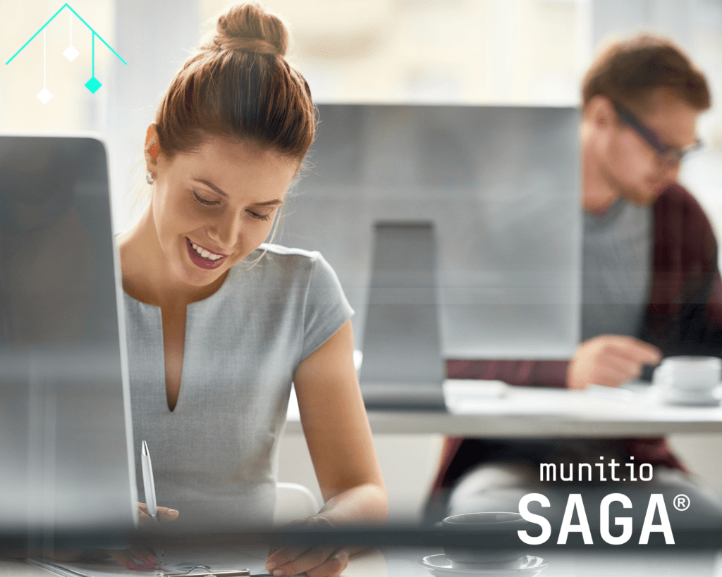 Professional woman working at a computer in a modern office, representing the practical application of iso 27001 vs 27002 for effective information security management.