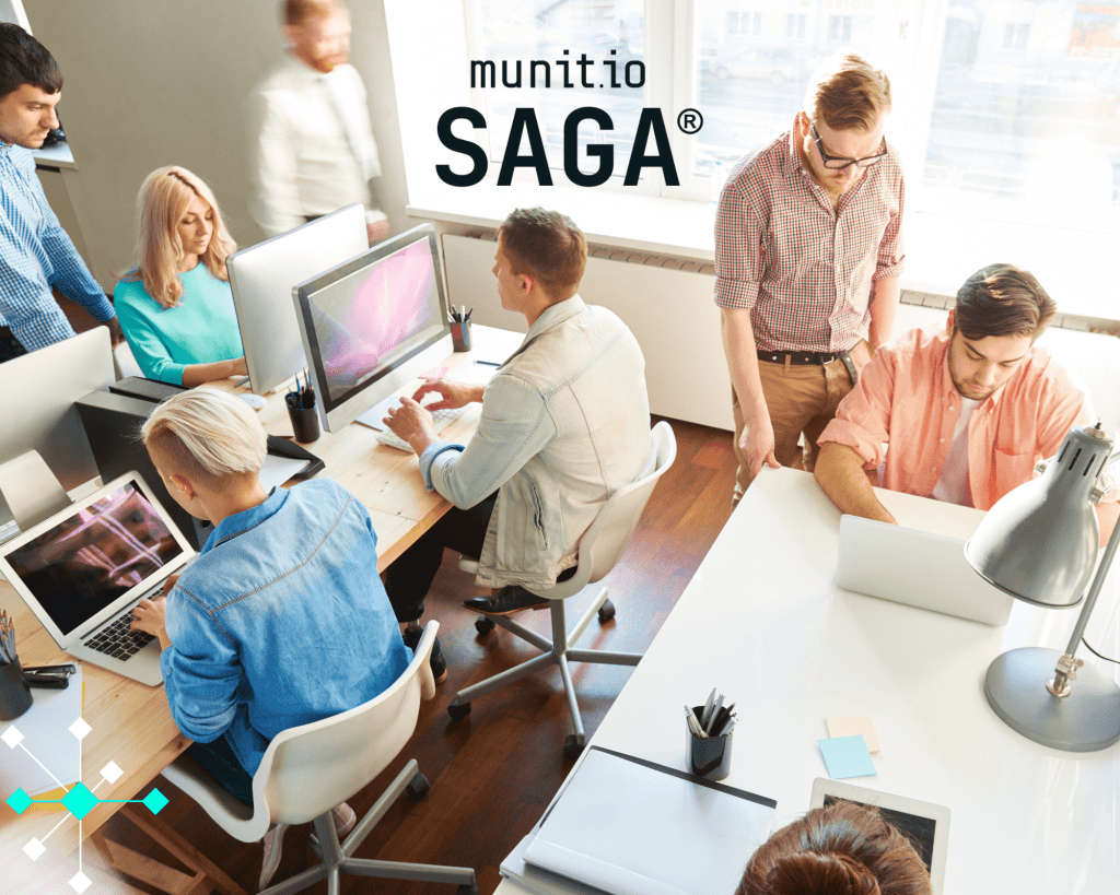 Team of professionals collaborating at computers in a modern office, reflecting the teamwork and governance needed for effective iso 27001 vs 27002 implementation.