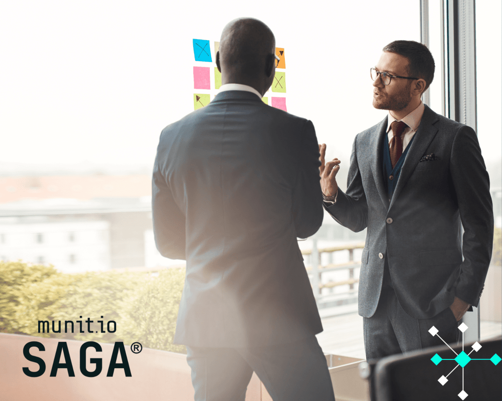 Two business professionals in suits are discussing strategy in front of colorful sticky notes on a glass wall, illustrating collaboration and planning in the context of what is an insider threat cyber awareness for organizational security.