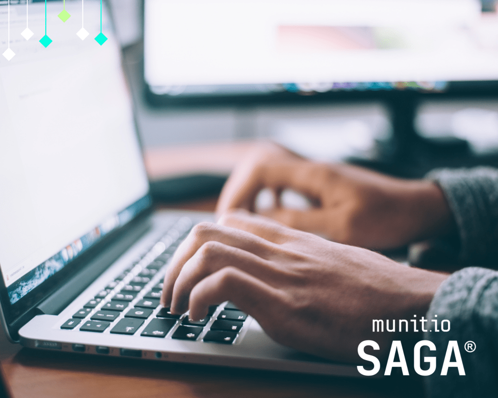 Hands typing on a laptop in front of a computer screen, reflecting the practical steps outlined in an NIS2 compliance checklist for SMEs.