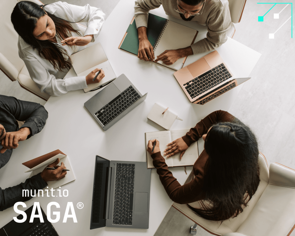 A group of professionals collaborating around laptops and notebooks illustrates best practices in cybersecurity awareness and training, emphasizing how to monitor stolen employee credentials to strengthen organizational defenses.