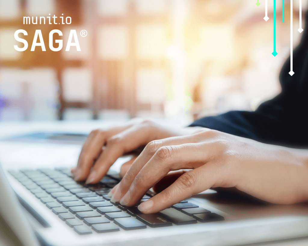 Hands typing on a laptop keyboard in an office environment, emphasizing the need for stolen password detection for businesses to protect compromised employee login data before it is exploited.