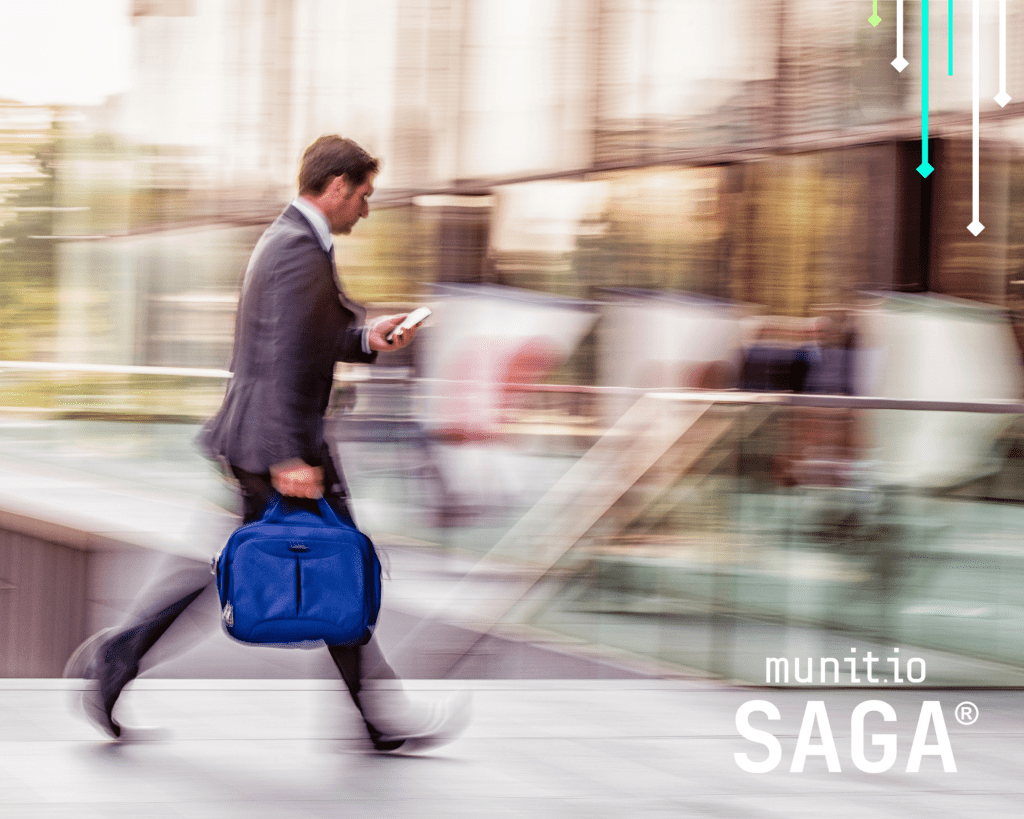 A business professional walking quickly with a briefcase and checking his phone, illustrating the urgency of implementing stolen password detection for businesses to prevent credential-based attacks.