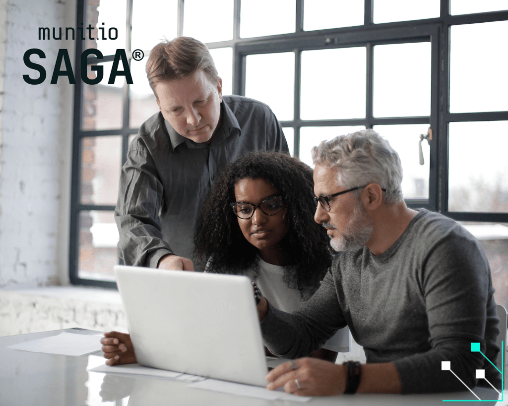 A team of colleagues reviewing data together on a laptop, supporting a discussion on how dark web marketplaces work and the threats they pose to organizations.