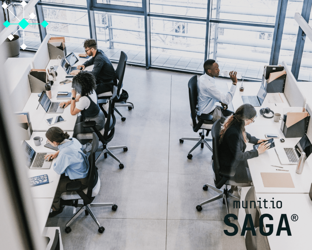 Teams working on laptops and digital tools in a modern office environment, illustrating how what is digital footprint analysis helps organizations understand their online exposure through employee and system activity.