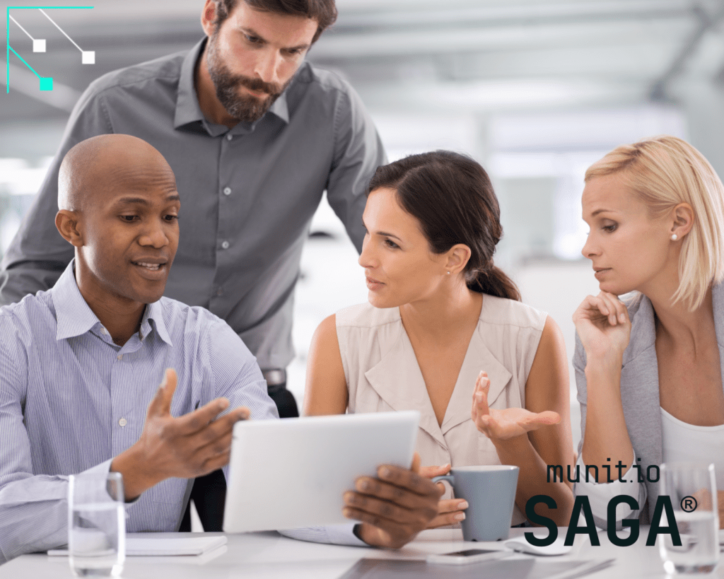 Business colleagues gathered around a tablet discussing on-screen information in a modern office, demonstrating How to detect fake support accounts through collaborative review and digital investigation.