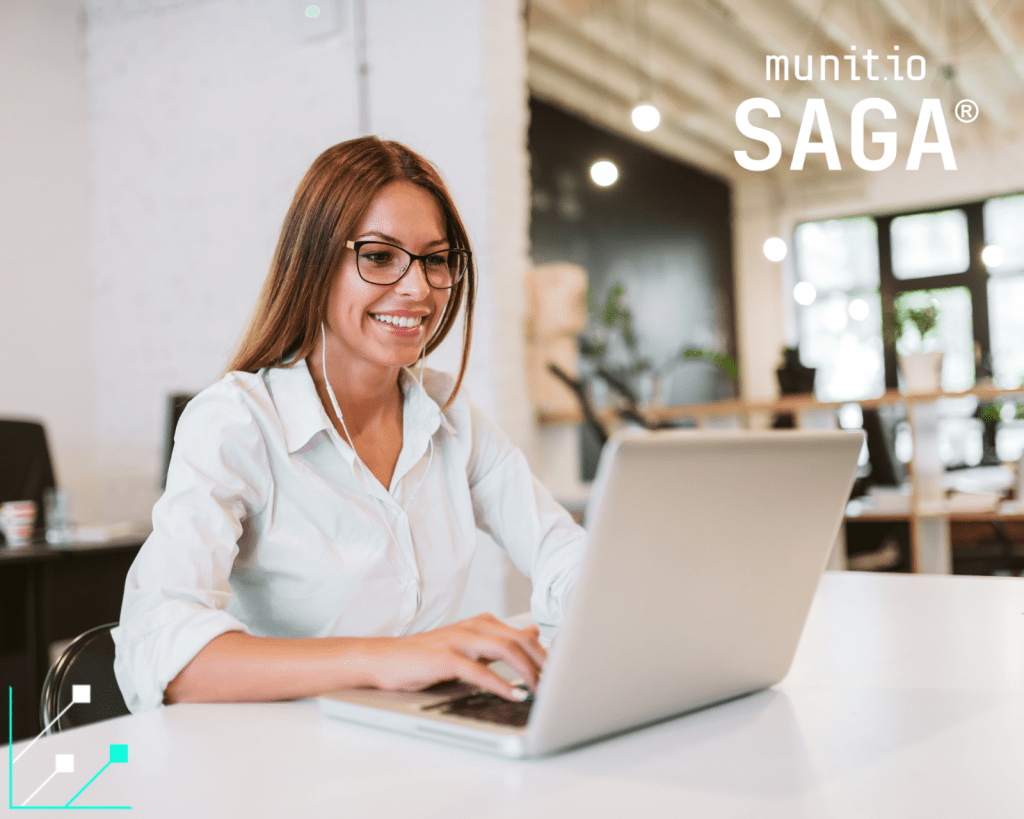 A professional woman wearing glasses works on a laptop in a modern office, illustrating How to protect your brand on social media through secure digital practices and attentive online engagement.