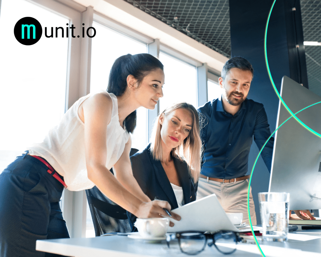 A team of business professionals reviewing documents and a computer screen in a modern office, demonstrating How do you know if your company data is on the dark web? through collaborative investigation and data analysis.