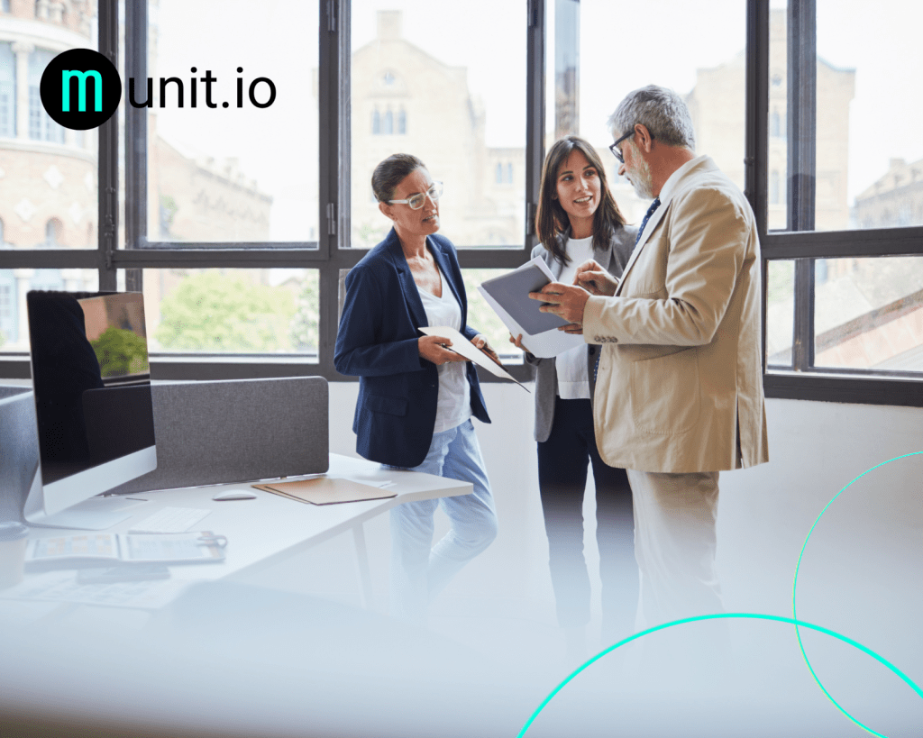 Three business professionals reviewing documents during an office meeting, illustrating How do you remove fake websites impersonating your brand? through collaboration on brand protection and digital risk management strategies.